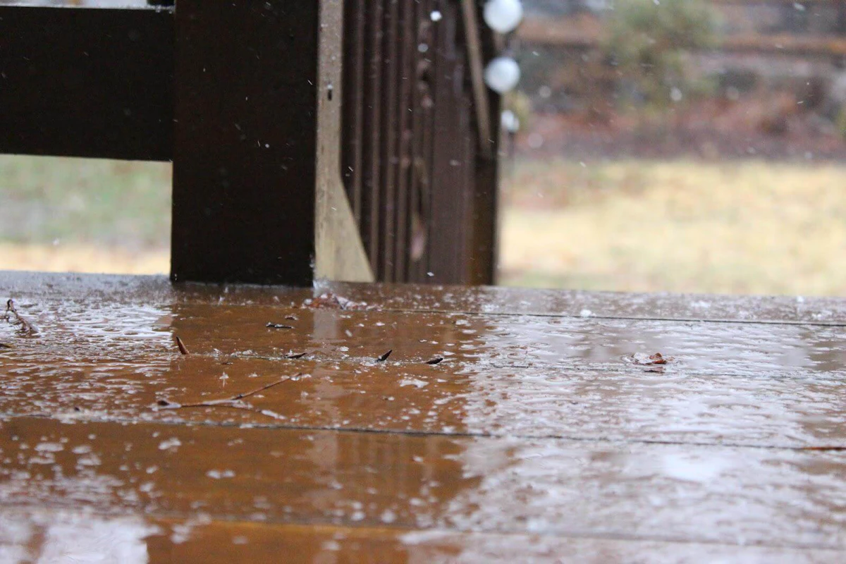 Rain pouring on a wood deck.