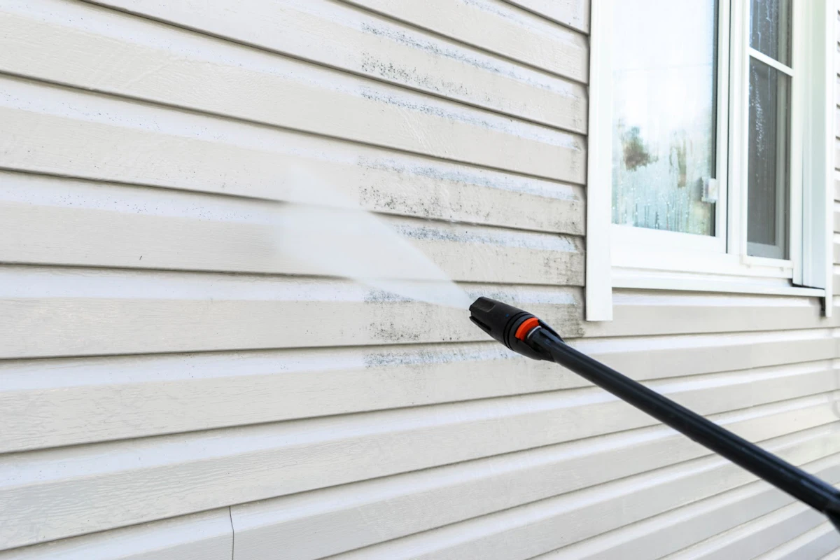 Power washer cleaning a home's siding