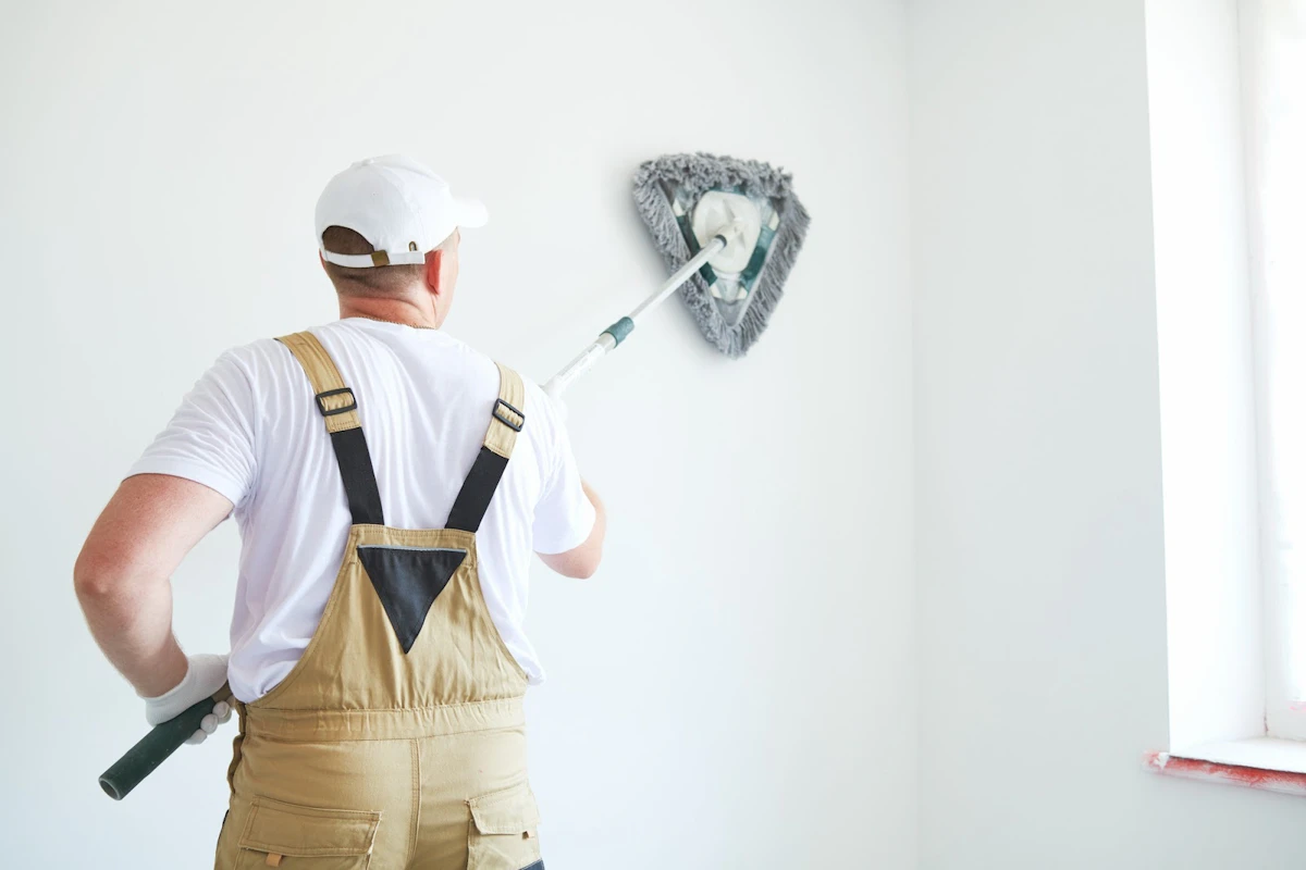 Painter brushing a white wall