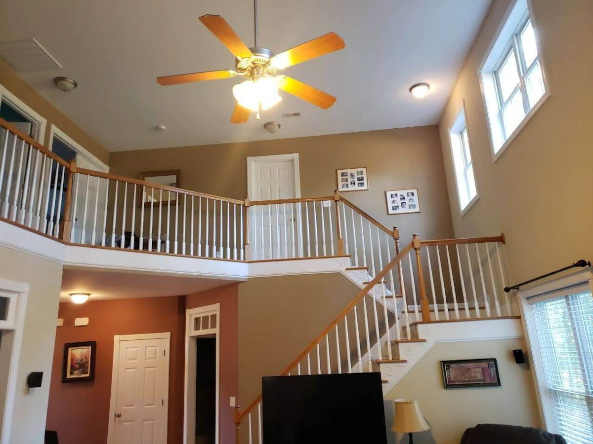 Lit-up ceiling fan inside of a house.