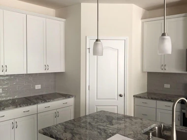 Newly painted white cabinets in a kitchen.